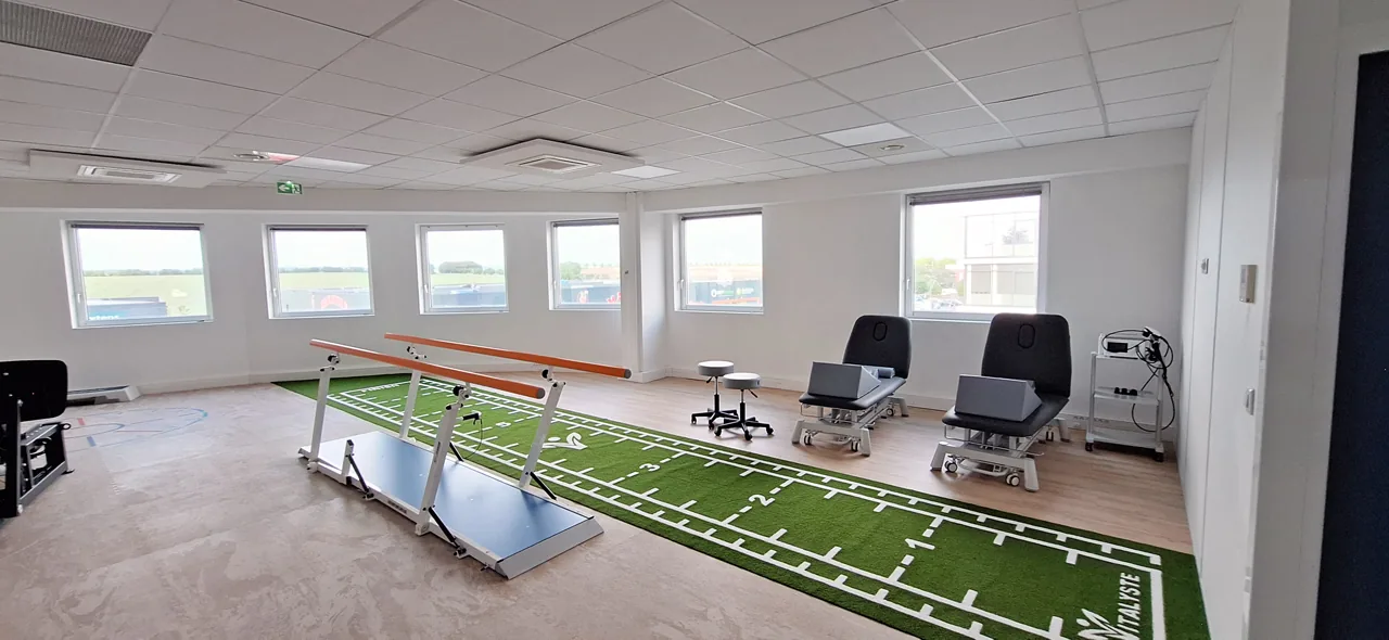Plateau de rééducation de Vitalyste Plaisir : piste verte, barres parallèles et tables de soins.